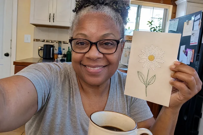 Denise R. avec sa broderie sur papier terminée